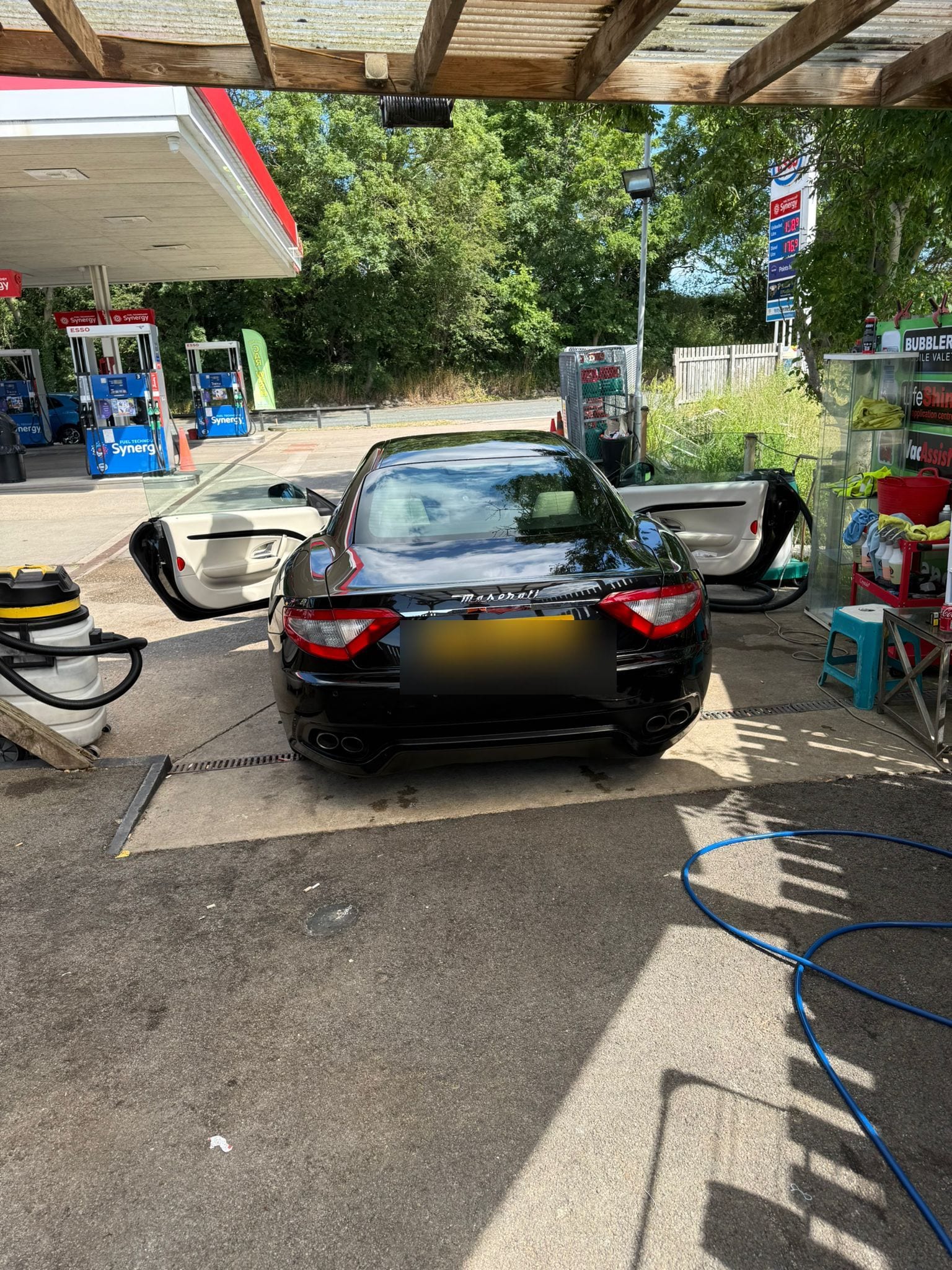 Freshly washed black Maserati on the forecourt